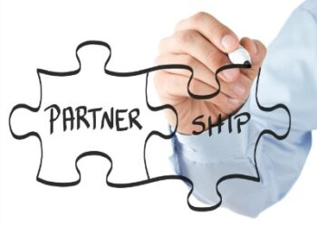 A hand drawing a Lego with partnership text