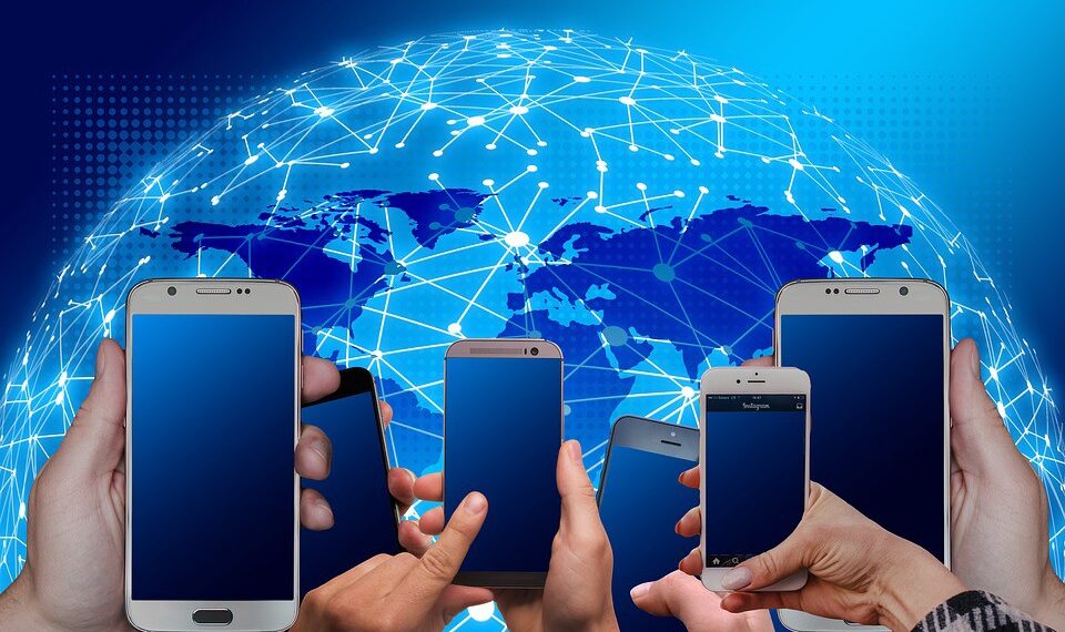 hands holding mobile phones with a globe in the background