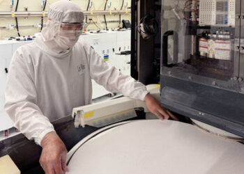 A technician installs an Optivision Max pad on a platen in Qnity’s polishing lab